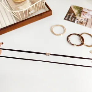 Elastic rhinestone hair tie set in coffee tones shown being stretched for durability