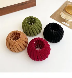 Detail view of flocked bird nest hair clips in four colors on a white surface