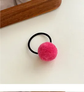 Detail of soft pink pompom hair tie with high-elastic black rubber band for girls