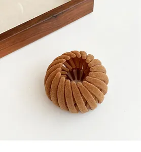 Macro detail of brown flocked bird nest hair clip showing soft velvet texture and teeth