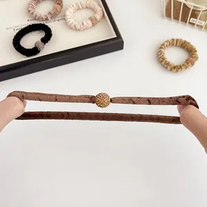 Velvet hair scrunchies with rhinestone spheres in earthy tones showing high elasticity
