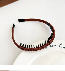 Détail du serre-tête en tissu marron montrant les dents antidérapantes en plastique