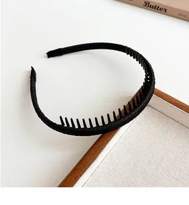 Detail van zwarte antislip hoofdband met kamtanden en stof op houten dienblad