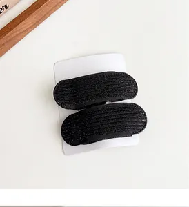 Primo piano di cuscinetti in velcro neri per capelli con trama fine in nylon su carta
