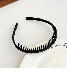 Détail d'un serre-tête noir en tissu avec dents antidérapantes sur assiette blanche