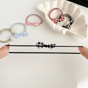 Elastic bow hair ties with checkered patterns shown being stretched for durability
