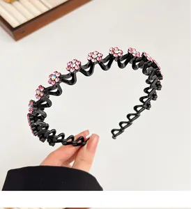 Detailoverzicht van de golvende antislip haarband met roze strass bloemen