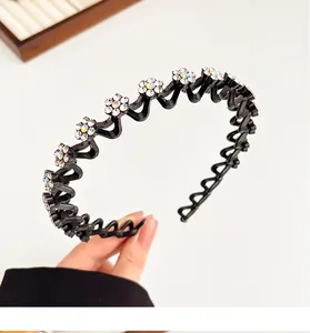 Detail van de intrekbare zwarte vogelnest haarclip met sprankelende strass bloemen