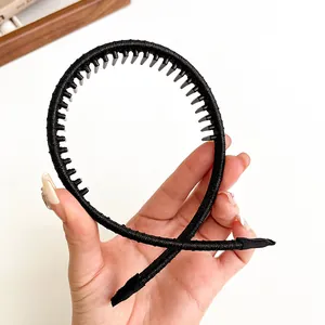 Flexibele zwarte stoffen haarband met tanden voor antislip grip, getoond op witte achtergrond
