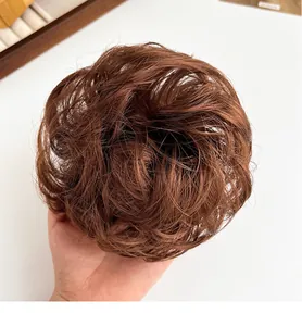 Detailopname van een groot donkerbruin haarstukje voor een natuurlijke knot-look
