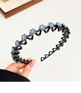 Close-up van een gegolfde antislip haarband met lichtblauwe strass bloemen