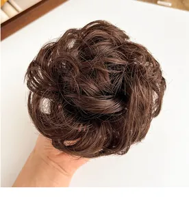 Detail van een groot pluizig donkerbruin haarstukje voor natuurlijk volume en een knotje