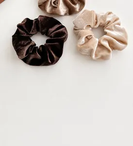 Detail van fluwelen haarelastiekjes in aardetinten met zachte textuur en luxe glans