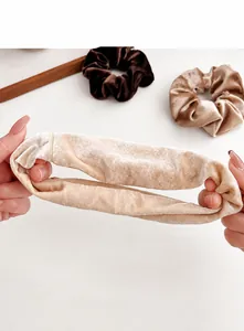Detail van de rekbaarheid en zachte fluwelen textuur van de champagnekleurige haarelastiek