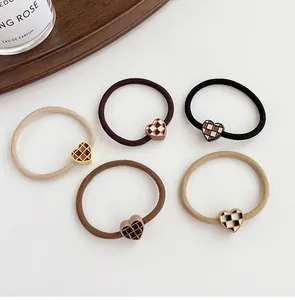 Detailed set of five elastic hair ties featuring vintage checkered heart accents