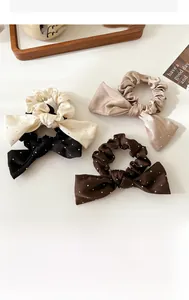 Détail de quatre chouchous nœuds en soie avec strass brillants en diverses couleurs