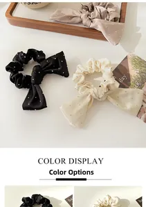 Détail de chouchous en satin avec nœuds et strass brillants en noir et couleur champagne