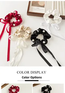 Detail of satin scrunchies with pearls and long ribbons in red, white, gold, and black