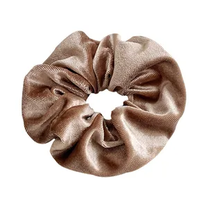 Elegante vintage fluwelen scrunchie in lichtbruin met zachte verticale textuur