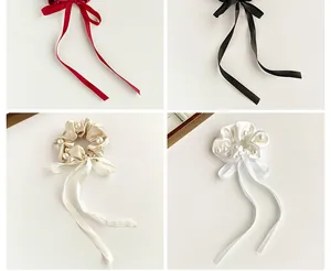 Detail view of satin bow hair scrunchies with elegant pearls and long ribbon streamers