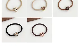 Close-up of checkered heart elastic hair ties in five neutral colors on white background