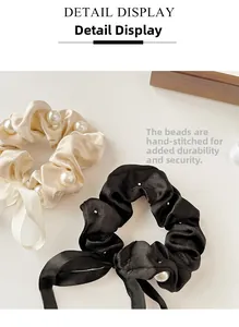 Detail of hand-sewn pearls on satin bow scrunchies with reinforced secure stitching