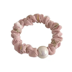 Chouchou fleuri rose avec une grande perle sur fond blanc pour femme