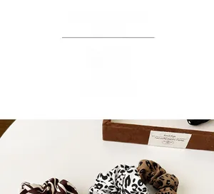 Detail shot of leopard and zebra print scrunchies with soft pleated fabric textures