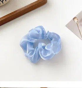 Detail eines hellblauen Organza-Haargummis mit Perlglanz-Finish und Faltenstruktur
