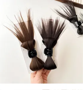 Detailed view of synthetic fiber hairpieces with claw clips on white display cards