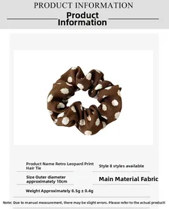 Close-up of a brown polka dot hair scrunchie showing 10cm diameter and fabric texture