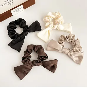 Détail des chouchous en satin avec nœud aux tons café et rubans élégants soyeux
