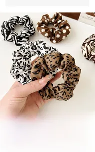 Detailed close-up of mixed leopard, zebra, and polka dot patterns on elastic hair scrunchies