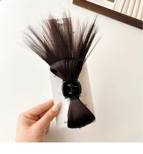 Detailed view of dark brown bow synthetic hair claw clip with feather-style texture