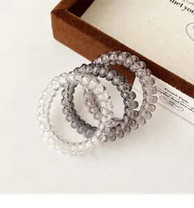 Three gradient clear grey spiral hair ties on a display tray for high-elastic hair styling