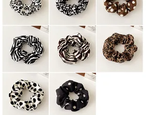 Collection of animal print hair scrunchies including leopard, zebra, and cow patterns