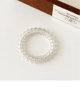 Close-up of clear spiral hair coil showing the transparent elastic material and texture
