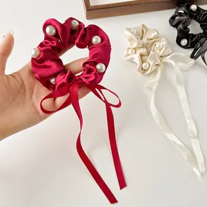 Elegant satin bow scrunchies with pearls and long ribbons in black, white, and wine red