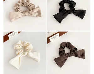 Vue détaillée des chouchous en satin avec nœud en champagne, noir, blanc et brun