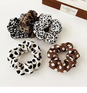 Detailed view of 5 leopard and polka dot print scrunchies with elastic fabric texture