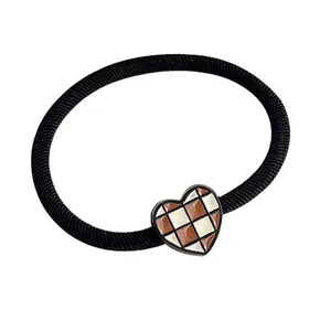 Elastic heart hair scrunchie with brown checkered pattern on a white background