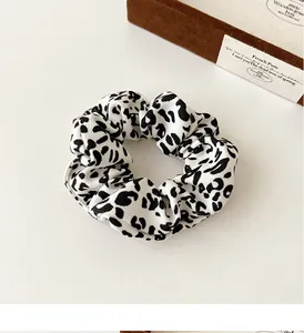 Detailed view of leopard print scrunchie with soft elastic fabric and ruffled texture