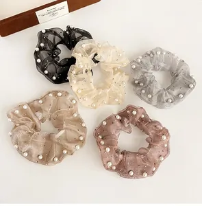 Détail de cinq chouchous en organza avec perles en noir beige gris champagne et rose