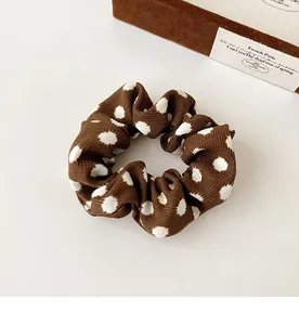 Macro detail of dark brown polka dot scrunchie fabric with a vintage French style