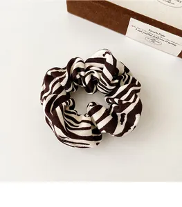 Close-up of zebra pattern fabric scrunchie showing detailed textile texture and elasticity