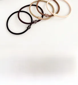 Detail of five durable coffee-toned elastic hair ties with matte heart charms