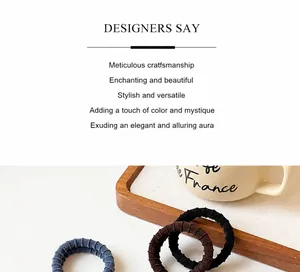 Detail of three ribbed hair ties in blue, brown, and black on a rustic wooden tray