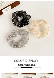 Gros plan de chouchous en organza avec perles en noir, argent et couleur champagne
