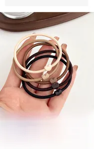 Detailed shot of five high-elasticity coffee-toned hair ties with matte heart charms