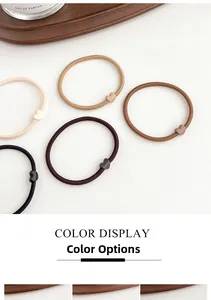 Detail view of heart-shaped elastic hair ties in neutral earth tones on wooden tray